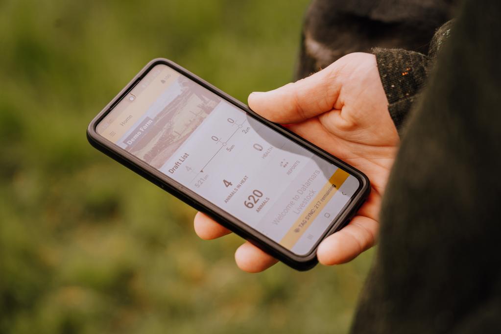 Farmer holding mobile farm with software app